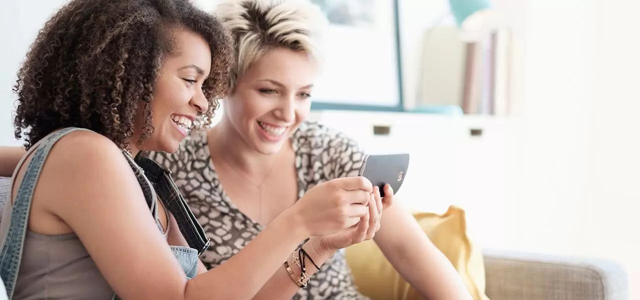 Two women watching something exciting on the phone