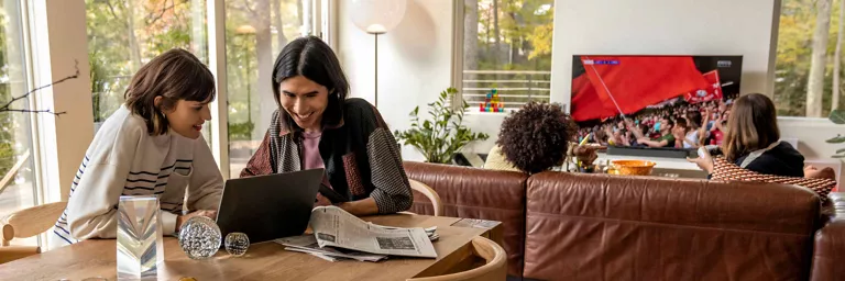 two people over laptop with show streaming in background