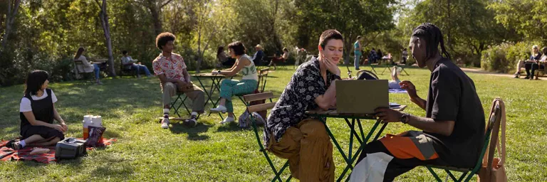 friends using laptop in a park