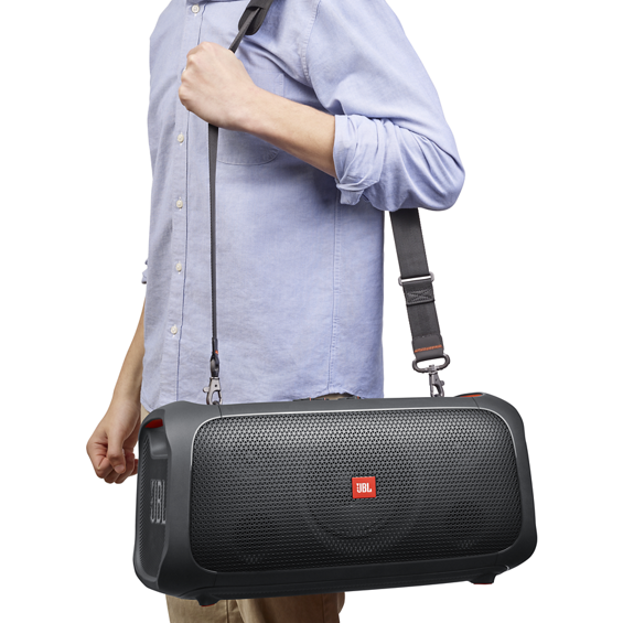 View of a man with a JBL Party Box On-The-Go over his shoulder.