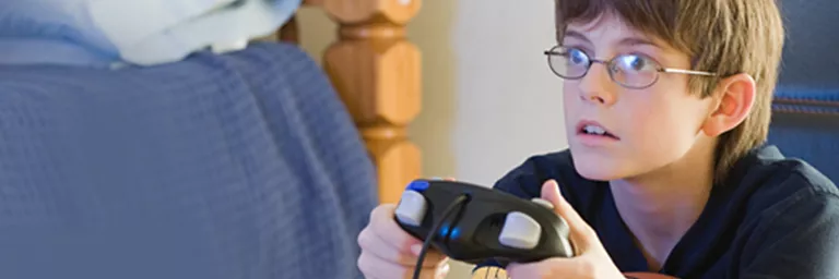 Kid with glasses playing a Gamecube