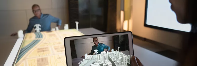 Man using tablet to visualize a design plan for a city